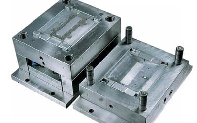 Two halves of an open injection mold, cavity and core, machined from metal plate