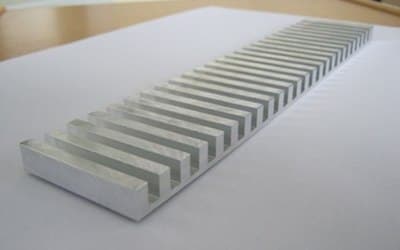 Comb-shaped test specimen machined from cast aluminum plate, lying flat on a reference surface
