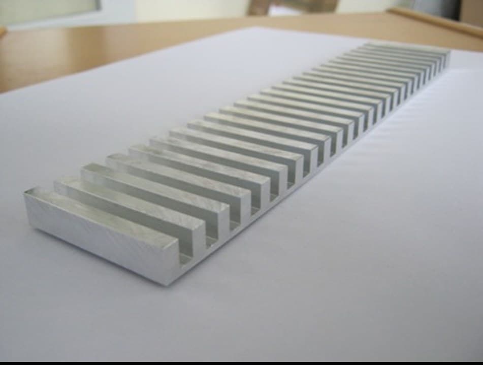 Comb-shaped test specimen machined from cast plate, sitting flat against the reference surface along its full length
