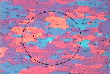 Polarised-light micrograph of rolled aluminium plate. The grains are flattened and drawn out into long horizontal bands running in the rolling direction.